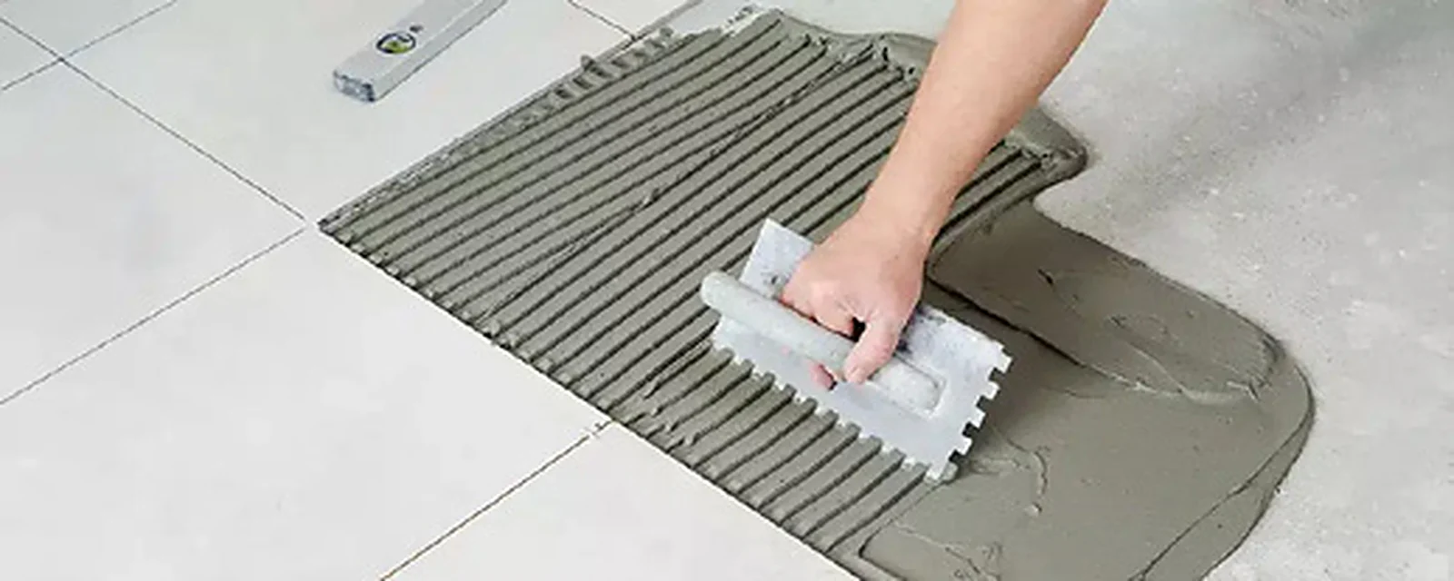 Trét keo Homecare lên nền bằng bay răng cưa trước khi dán gạch